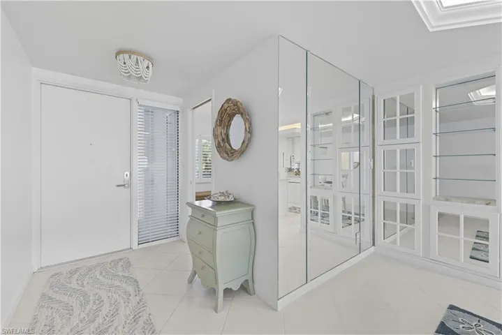 Foyer entrance featuring light tile patterned flooring and a skylight