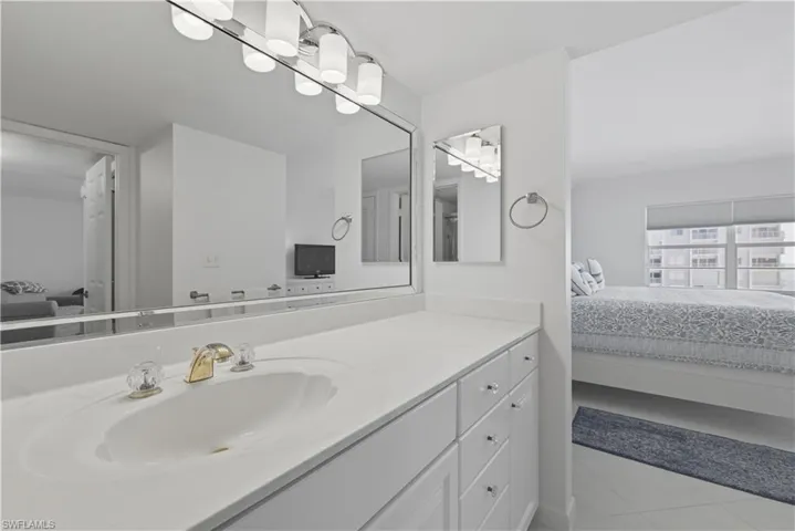 Bathroom with connected bathroom, vanity, and light tile patterned floors