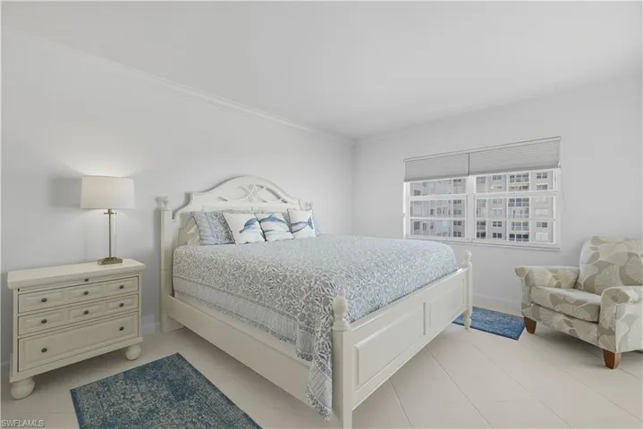 Bedroom with crown molding and light tile patterned floors