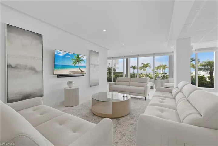 Living area with recessed lighting, plenty of natural light, and a wall of windows