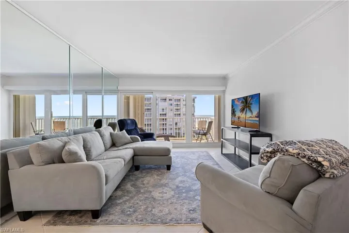 Living area featuring light tile patterned flooring and ornamental molding