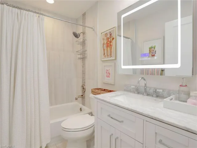 Guest bathroom connected to guest bedroom w/ tub/shower combination & lighted mirror & new vanity