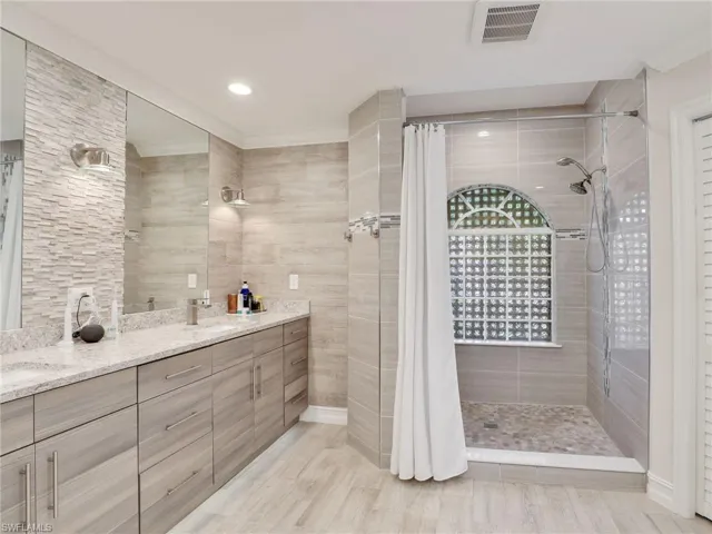 Primary bathroom w/ walk in tiled shower & multiple shower heads