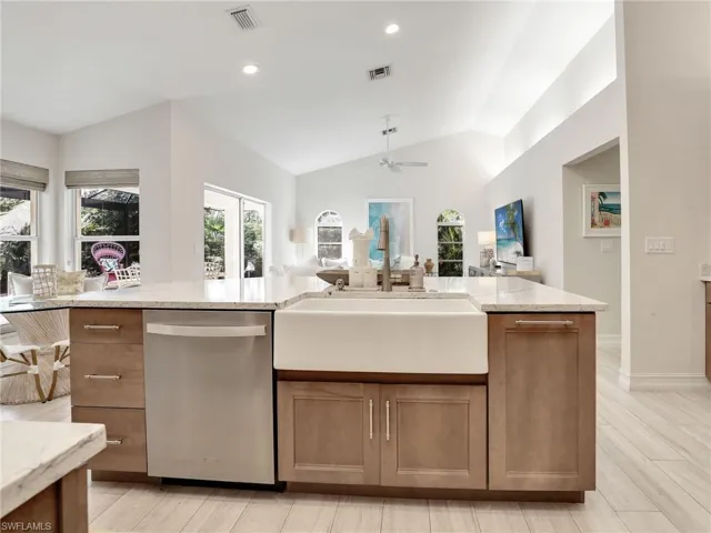 Kitchen island with stainless steel dishwasher & white farmhouse sink