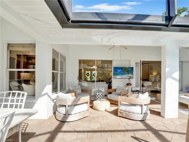 Large L shaped covered lanai with sliders to living room, family room & primary bedroom