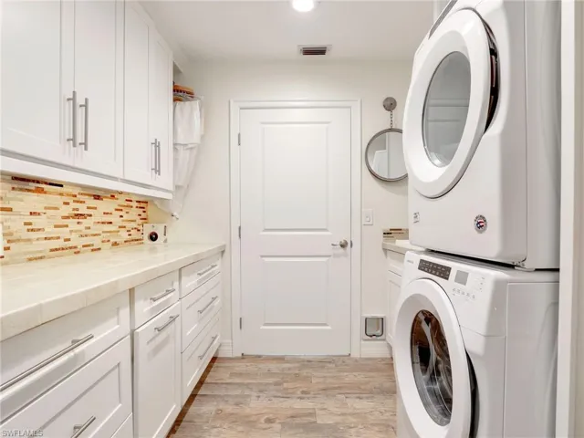 Laundry room w/ stackable Amana washer & dryer, upper & lower cabinetry, lots of counterspace & utility sink (not pictured)