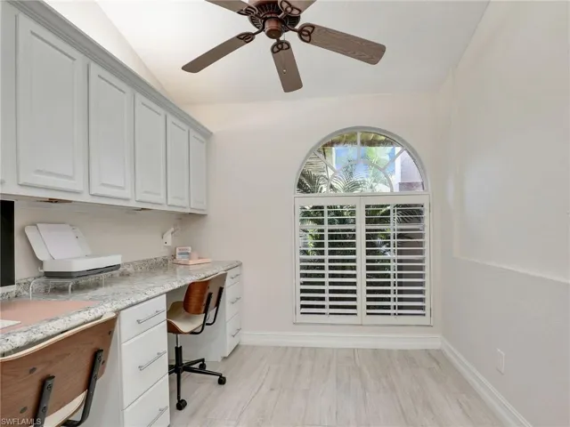 Den with built-in desk, upper cabinets & plantation shutter