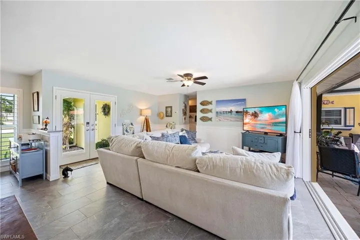 Living room featuring ceiling fan and french doors
