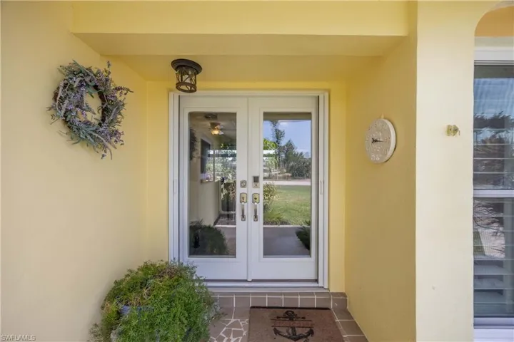 Property entrance with stucco siding and french doors
