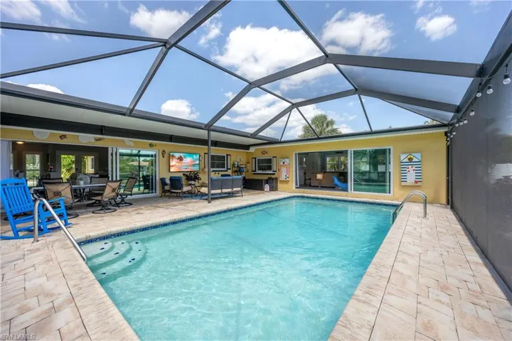 Pool featuring ceiling fan, outdoor dining area, an outdoor living space, a patio area, and a lanai