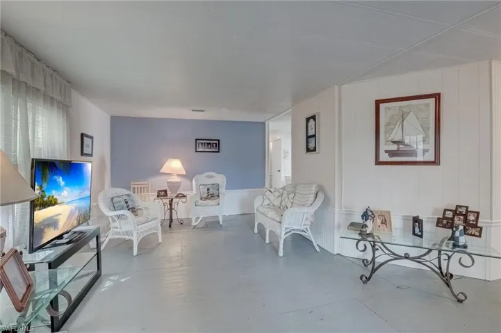 Sitting room featuring finished concrete floors, a decorative wall, and wood walls