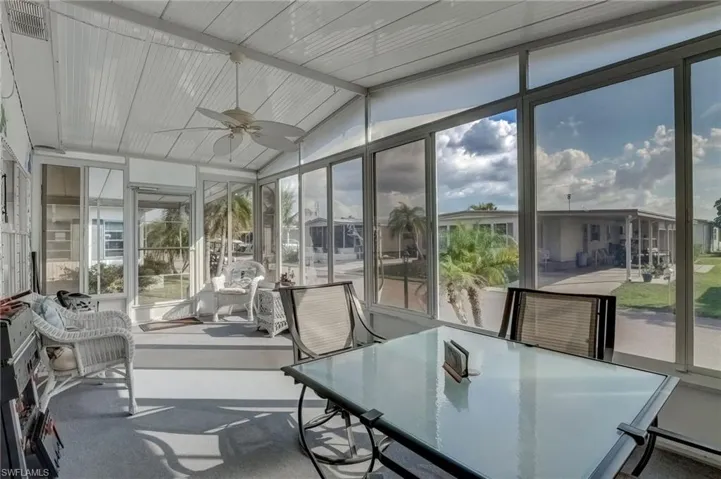 Sunroom with a ceiling fan, outdoor dining space, and vaulted ceiling