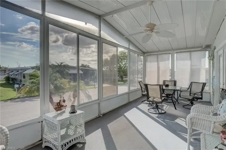 Sunroom / solarium with ceiling fan, vaulted ceiling, and outdoor dining area