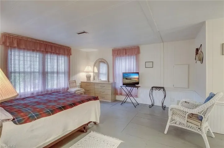 Bedroom featuring multiple windows and concrete flooring