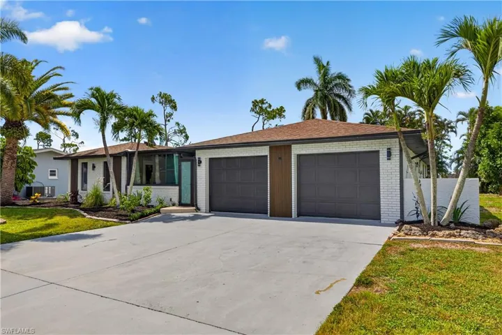 Contemporary exterior with white brick, dark gray siding, and a brown shingle roof