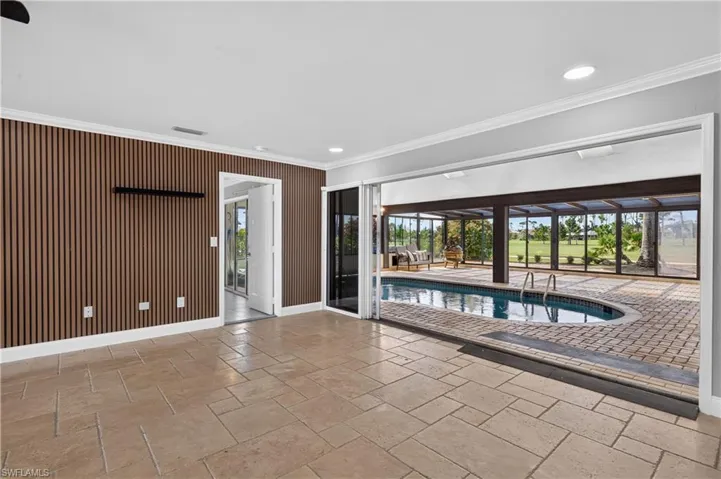 Indoor-outdoor living space featuring stone tile flooring and a slatted accent wall