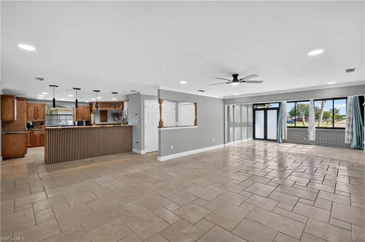 Spacious open-concept living area featuring large format tile flooring and recessed lighting