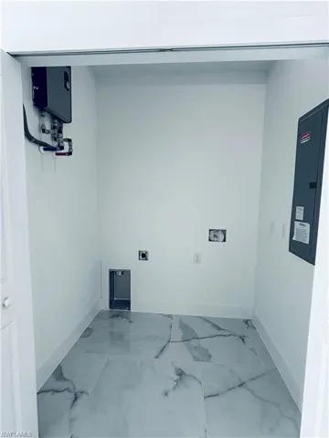 Laundry area with electric panel, marble look tiles, electric dryer hookup, water heater, and washer hookup