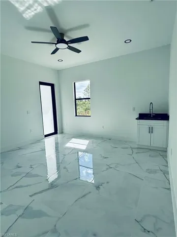 Living area featuring light marble finish floors and recessed lighting