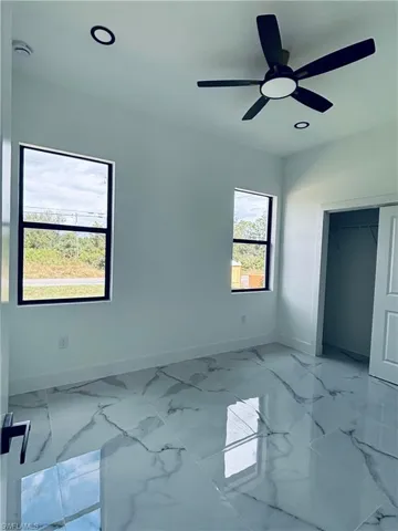 Unfurnished room featuring light marble finish flooring, recessed lighting, and a ceiling fan