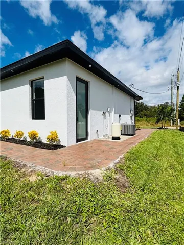 Back of house featuring a yard, a patio area, and stucco siding