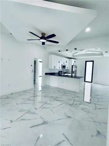 Living area featuring light marble finish flooring, recessed lighting, and ceiling fan