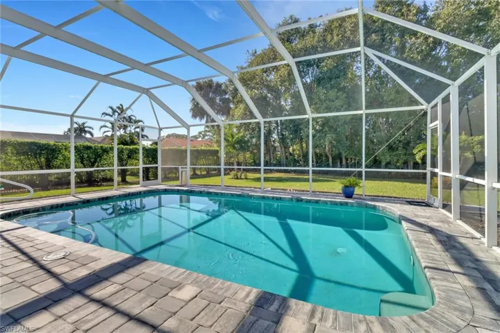 View of pool with a lanai, a lawn, and a patio