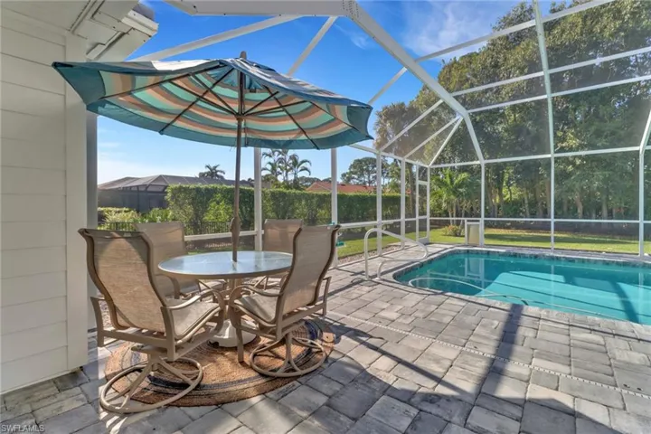 View of pool featuring glass enclosure and a patio area