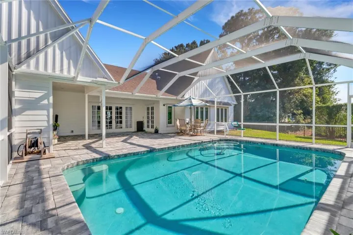 View of swimming pool with a lanai, a patio area, and french doors