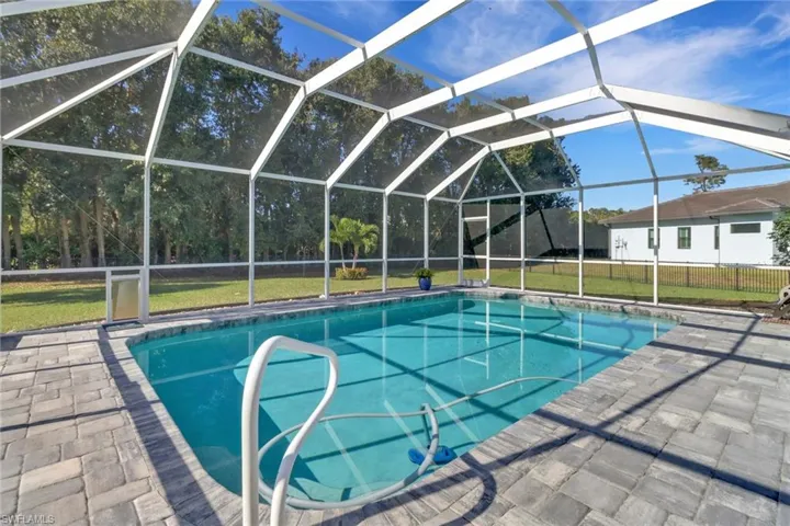 View of pool with a patio area, a lanai, and a lawn