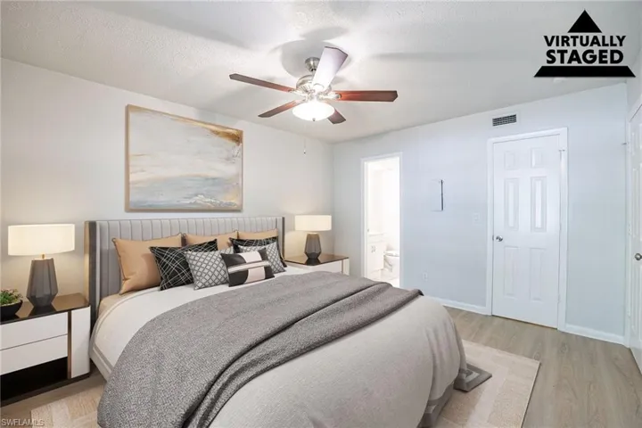 Bedroom with light wood-style flooring, ensuite bathroom, and a ceiling fan