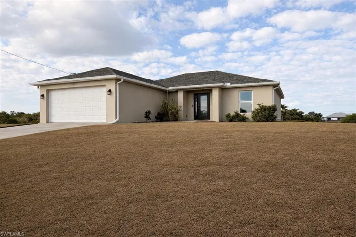 Single story home with stucco siding, a front yard, concrete driveway, and an attached garage