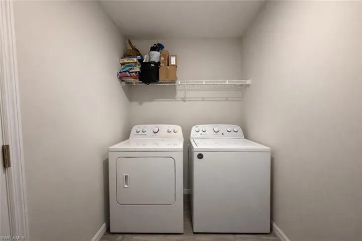 Laundry room featuring washing machine and dryer and baseboards