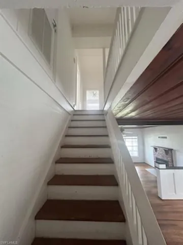 Stairway featuring wood finished floors