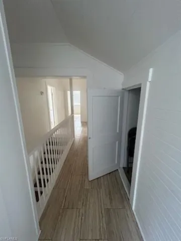 Hall featuring vaulted ceiling and wood finish floors