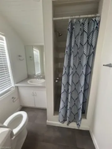 Bathroom with a shower with curtain, vanity, and tile patterned flooring