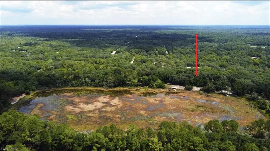 Aerial view of property and surrounding area with a heavily wooded area