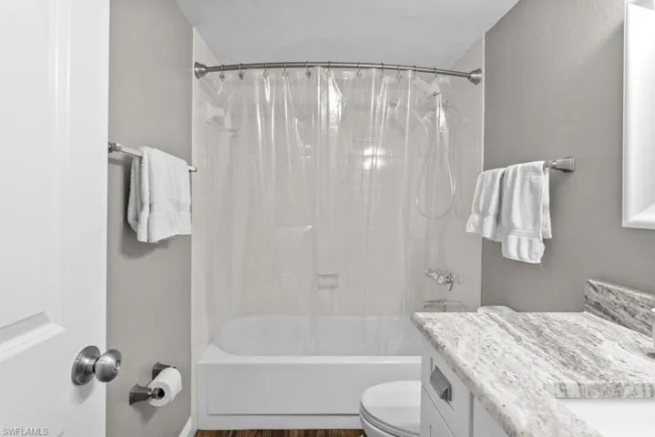 Bathroom featuring tile walls, vanity, tile patterned flooring, a shower, and a wainscoted wall