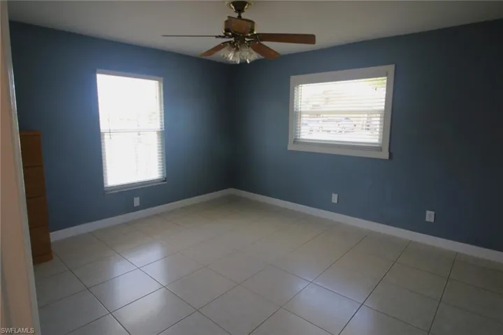 Spare room with tile flooring, ceiling fan, and a healthy amount of sunlight