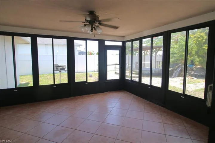 Unfurnished sunroom with ceiling fan