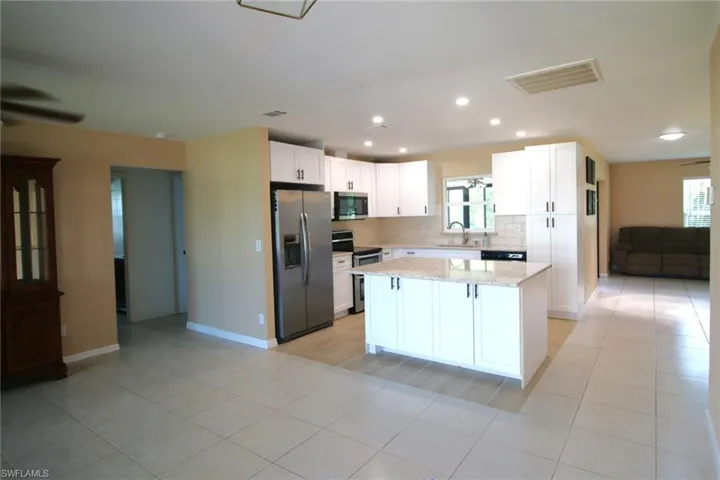 Kitchen featuring white cabinets, plenty of natural light, and stainless steel appliances