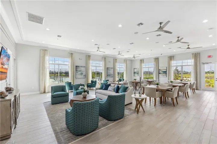 Living room with light wood-type flooring, recessed lighting, ceiling fan, crown molding, and baseboards