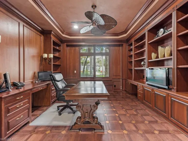 Home office with built in study area, a ceiling fan, wooden walls, built in features, and ornamental molding