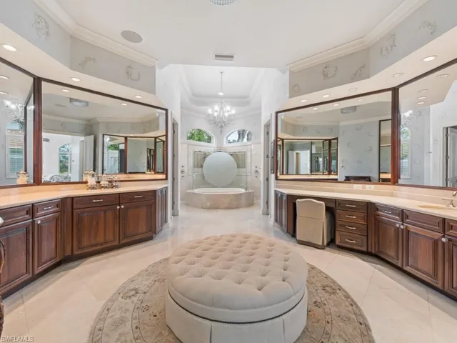Full bathroom with visible vents, crown molding, a sink, a garden tub, and an inviting chandelier