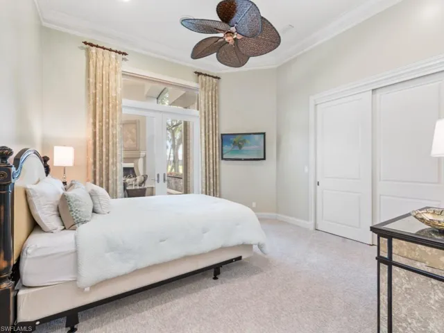 Carpeted bedroom featuring a closet, crown molding, baseboards, and ceiling fan