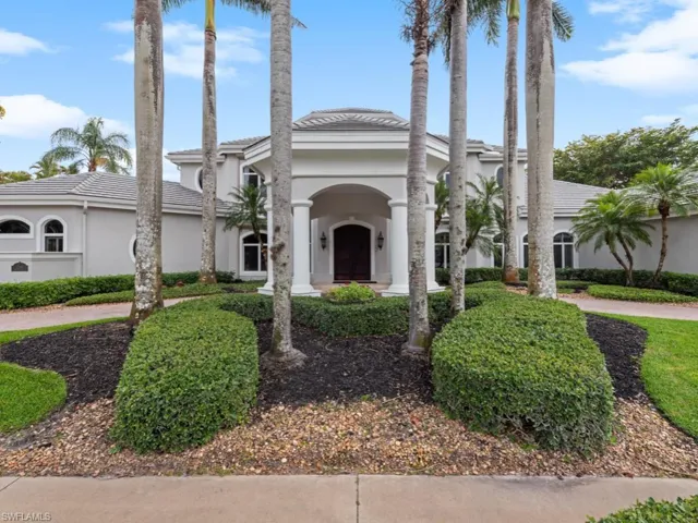 Greek revival house featuring stucco siding and a tiled roof