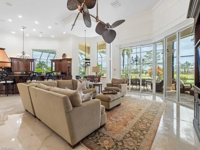 Living room with marble finish floor, a high ceiling, and crown molding