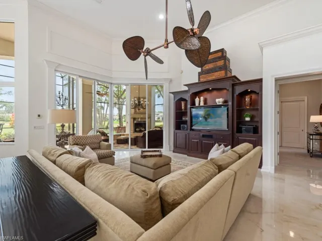 Living area with a high ceiling, marble finish floor, ornamental molding, and a fireplace