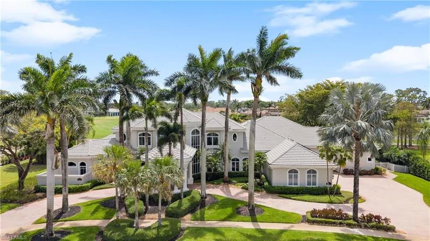Mediterranean / spanish house with stucco siding, a tiled roof, curved driveway, and a front yard