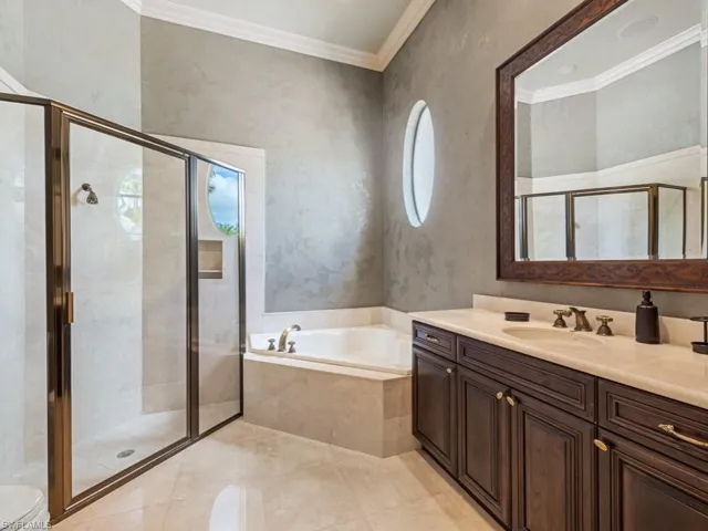 Full bath featuring vanity, crown molding, toilet, a shower stall, and a bath